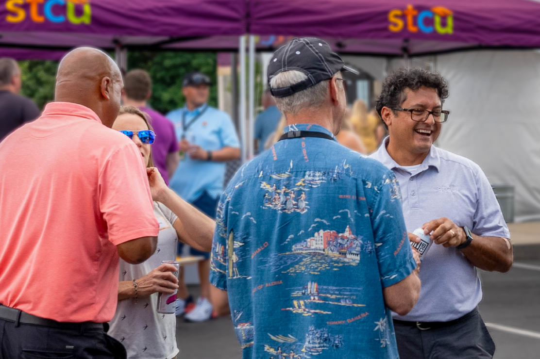 Photo of a man in an STCU shirt putting a mountain bike on top of an SUV