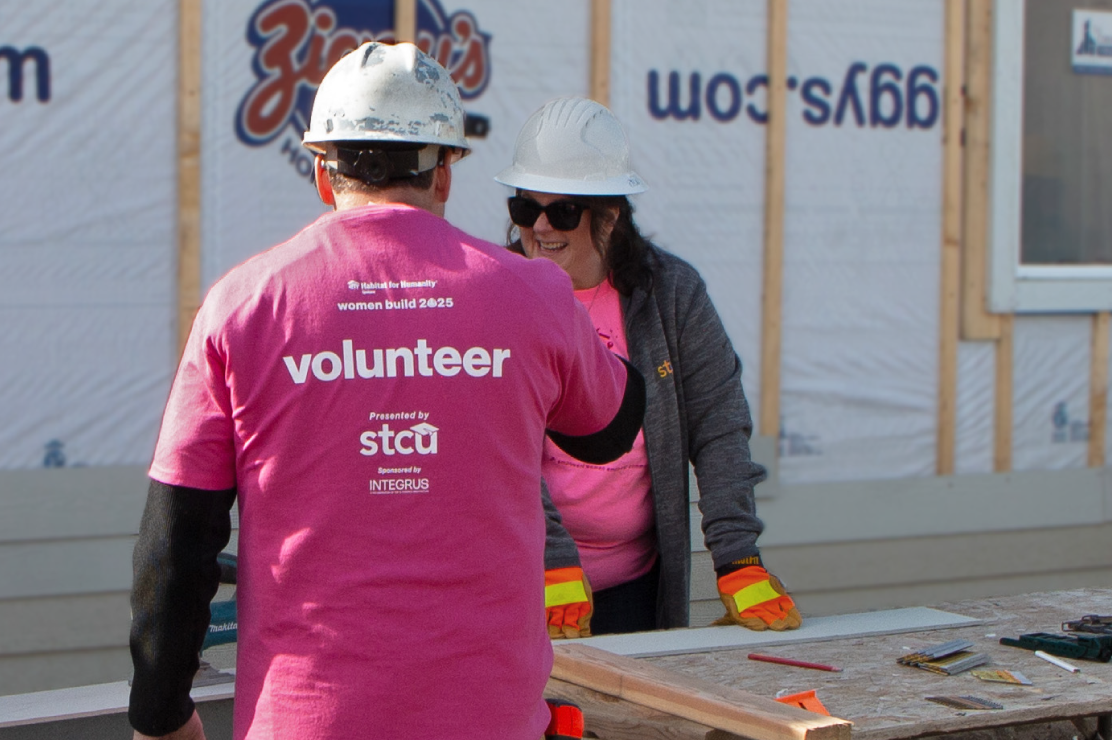 A man and a women building a house at a Habitat for Humanity event.