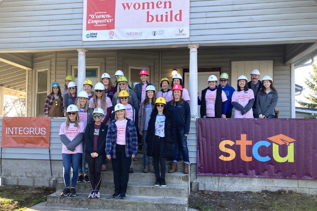 Photo of STCU employees in hard hats in front of a house