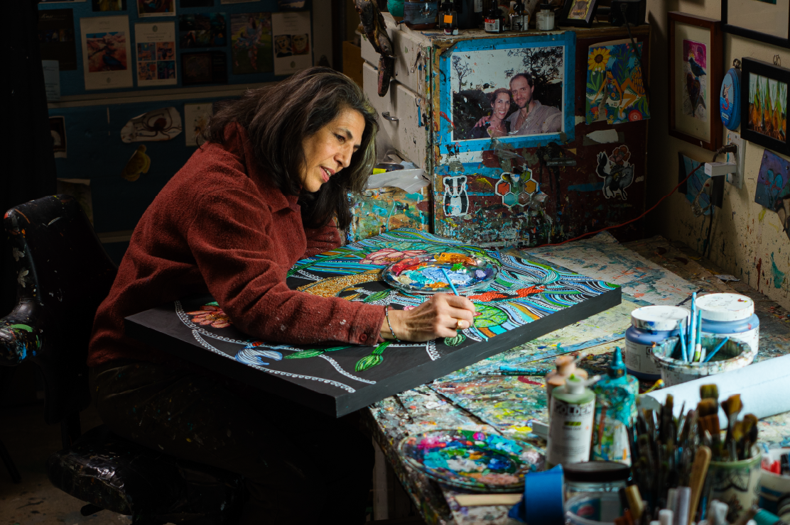 Photo of a female artist painting in her studio